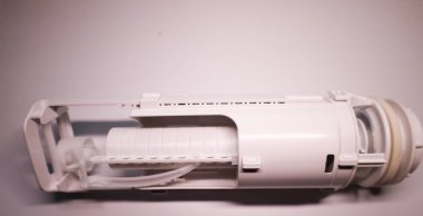Ukrayna 'da yeni bir tuvalet tankı sifonu mekanizmasının yan görüntüsü. Plastik mekanizma silindirik bir gövde, kollar ve bağlayıcılardan oluşur..