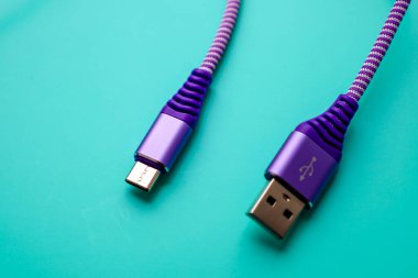 Mor USB Tip-A 'dan Micro-USB' ye kablo parlak bir turkuaz arka planda yatıyor. Bir uçta, sembollü bir USB Tip-A konnektörü görünür, ve diğer uçta, bir Micro-USB konnektörü.