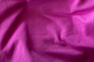 Yumuşak kıvrımları ve görünür dokusu olan canlı bir fuşya kumaşı. Bu resim arka plan, vitrin malzemeleri veya moda ve tasarım ile ilgili projeler için idealdir..