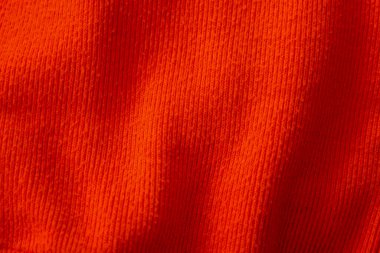 Görünür dokusu ve yumuşak kıvrımları olan yoğun turuncu kurdeleli kumaş. Bu çekim malzeme, arka plan veya tekstil ve moda ile ilgili projeler için mükemmeldir..