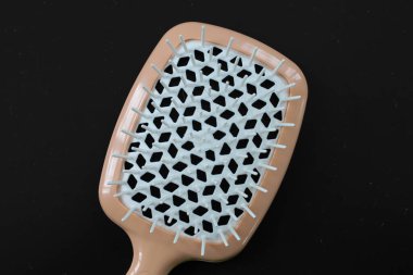 Esmer arka planda şık bir kadın saç fırçası, e-ticaret için ideal. Modern tasarımı ve nötr renkleri onu herhangi bir katalog veya reklam kampanyası için çok yönlü bir ürün haline getiriyor..