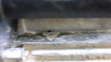 Güçlü bir motorun titreşen yüzeyinde seken metal bir fındık yakın plan. Dinamik makro görüntüler bileşenlerin hareketini ve etkileşimini gösterir, mekanik süreçlerin altını çizer.