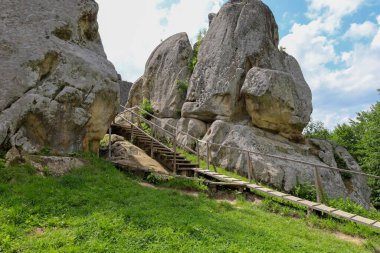 Ahşap merdivenler ve ziyaretçiler için patikaların döşendiği devasa kaya oluşumlarıyla pitoresk bir manzara. Bu çekim vahşi doğa ve turist altyapısının eşsiz bir kombinasyonunu gösteriyor..