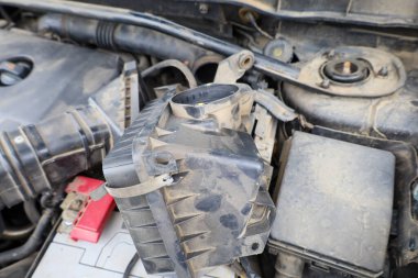 Açık hava filtresi yuvası motor bileşenlerini ortaya çıkarır. Bu da bakım ve onarım sürecini gösterir. Birikmiş toz, ideal performans için düzenli temizlik ve bileşen değişimine duyulan ihtiyacı vurgular.