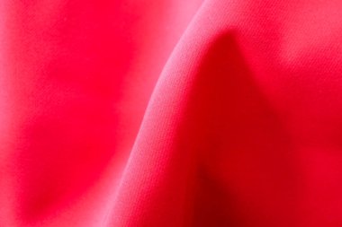 Yumuşak kıvrımlı ve dalgalı hatları olan parlak kırmızı kumaş, dinamik ve çekici bir doku yaratıyor. Zengin renk ve dolgun biçimler soyut arkaplan ya da tasarım için idealdir..