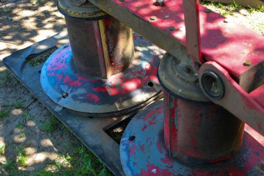 Soluk kırmızı boya ve metalik parçaları olan tarımsal makinelerin detayları aktif kullanımı gösteriyor. Görüntü, tarım, ekipman veya endüstriyel tasarım ile ilgili konular için uygun bir özgünlük ve çalışma ortamı taşır..