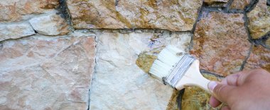 Bir fırça dış doğal taş duvar için temiz bir kaplama uygular. Düzensiz şekilli bloklardan oluşan duvar, yüzeyin dokusunu ve rengini yükselterek derin bir ıslak parıltı kazanır..