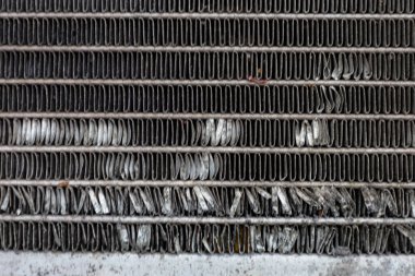 Hasarlı metal şeritler dokulu bir arka plan oluşturur. Eğri çizgiler ve gri gölgeler detaylı bir endüstriyel model oluşturuyor. Bu çekim, yıpranmış metal bir yüzeyin yakın görüntüsünü yakalar..