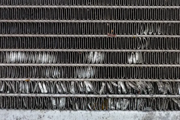 Hasarlı metal şeritler dokulu bir arka plan oluşturur. Eğri çizgiler ve gri gölgeler detaylı bir endüstriyel model oluşturuyor. Bu çekim, yıpranmış metal bir yüzeyin yakın görüntüsünü yakalar..