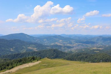 Ufuk çizgisine kadar uzanan yamaçlarda sık ormanlarla kaplı bir dağ manzarası, küçük köylerin görülebildiği, pitoresk bir manzara yaratıyor..