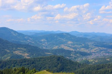 Ufuk çizgisine kadar uzanan yamaçlarda sık ormanlarla kaplı bir dağ manzarası, küçük köylerin görülebildiği, pitoresk bir manzara yaratıyor..
