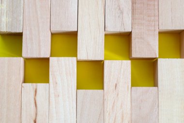 Hafif ahşap blokların geometrik bileşimi sarı karelerden oluşan bir desen oluşturuyor. Bu fotoğraf, yapım, yaratıcılık ve tasarım ile ilgili fikirleri görselleştirmenin yanı sıra sunumlar ve reklamlar için bir arka plan olarak kullanmak için idealdir. 