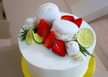 Süslü, beyaz kremalı bir pasta taze ve şenlikli bir imaj yaratıyor. Taze meyveler, turunçgiller, bezelyeler ve üzerine yerleştirilmiş badem kurabiyeleri sofistike ve lezzeti ön plana çıkarır..