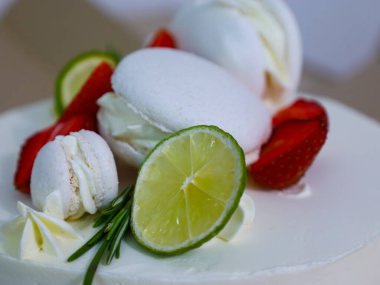 Taze meyve ve tatlılarla süslenmiş bir pasta. Şenlikli ve iştah açıcı bir görünüm yaratıyor. Limonlu, çilekli ve kremalı zarif tasarım sofistike ve tazelik katıyor..