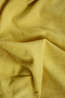 Yumuşak sarı kumaşın dokusu doğal kıvrımlar ve gölgeler oluşturuyor. Bu çok yönlü fotoğraf moda, tekstil, ev dekorasyonu veya soyut sanatla ilgili projeler için mükemmeldir.. 