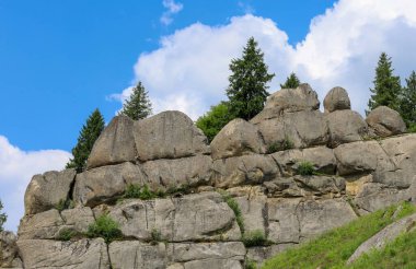 Büyük taş kayalar mavi gökyüzüne doğru yükselen büyük bir uçurum oluşturur. Issız ağaçlar tepelerinde ve yamaçlarında yetişir ve gri taşlarla yeşillikler arasında pitoresk bir kontrastlık yaratır..