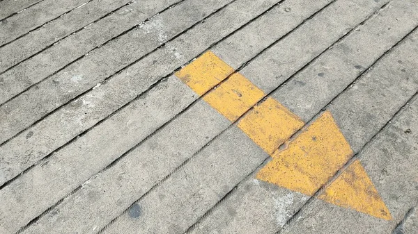 Κίτρινο Βέλος Σημάδι Στον Ασφαλτοστρωμένο Δρόμο — Φωτογραφία Αρχείου