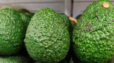  Bir rafta duran bir avuç yeşil avokado.