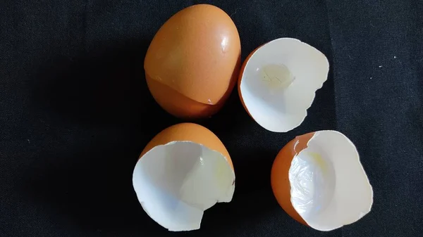 white eggs and broken eggs on a black background
