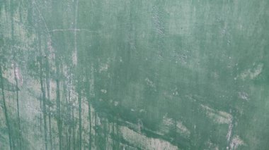 Beyaz tuvaleti ve siyah klozeti olan yeşil bir duvar.