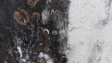 Yangın musluğu olan siyah beyaz bir duvar.