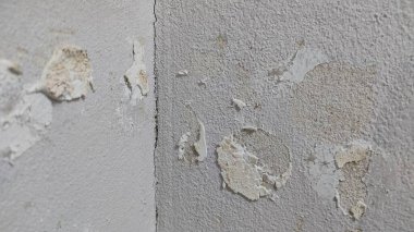 Soyulmuş bir duvar ve üzerinde bir saat var.