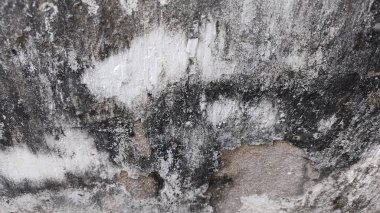 Bir sürü siyah beyaz boyası olan kirli bir duvar.