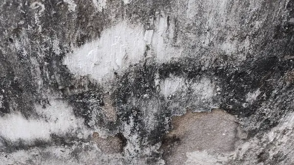 Bir sürü siyah beyaz boyası olan kirli bir duvar.