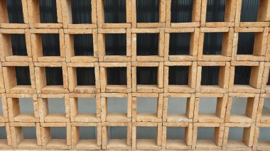 Duvarda gölgesi olan kahverengi ahşap çit.