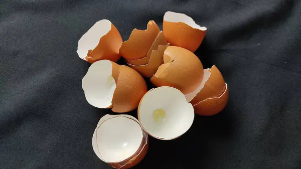 Siyah bir masadaki kasede bir sürü kırık yumurta.