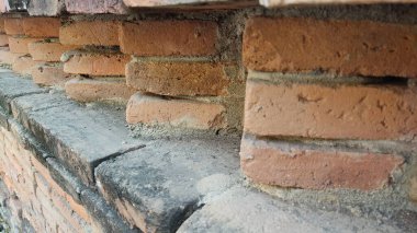 Kırmızı tuğlaları ve taşları olan eski tuğla duvar