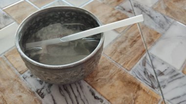 Bir kaşık ve bıçakla bir bardağın dikey görüntüsü.