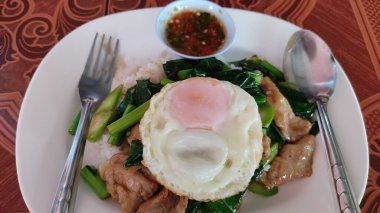 Fesleğenli sahanda yumurta ve kızarmış tavuk.