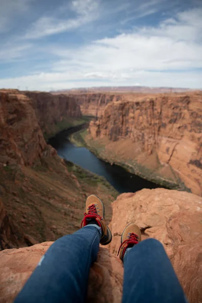 brown red boots hanging off of a canyon in Arizona