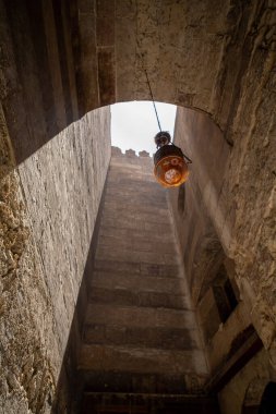 Eski cam lamba, eski tuğla kemerli tavandan sarkıyor. 