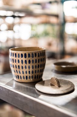 El yapımı, beyaz, nötr ve benekli bardak kapağı ve kısa çizgili deseni var.