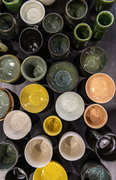 Top view flay lay composition of table full of different colours shapes and sizes handmade speckled pottery ceramics cups bowls