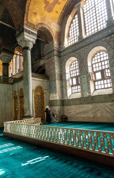 Türkiye 'de eski bir camide namaz kılan iki kadın, geniş kavisli pencereli.