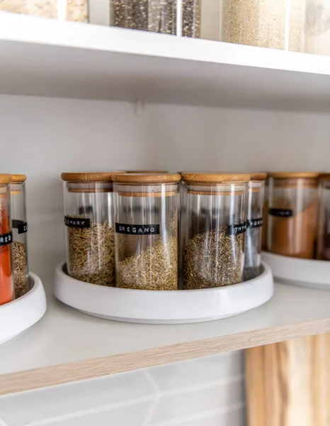 stock image Neatly organized labeled food pantry in a home kitchen with spices in glass wooden spice jars