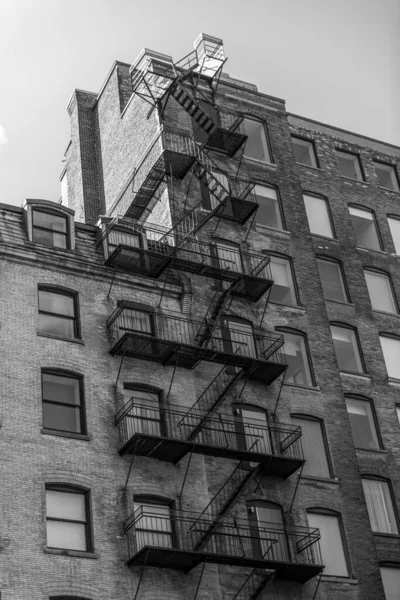 stock image Black and white photo of the exterior of a building in Montreal with a fire escape