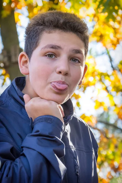 Boy Standing Autumn Park Shows His Tongue — Stock Photo, Image