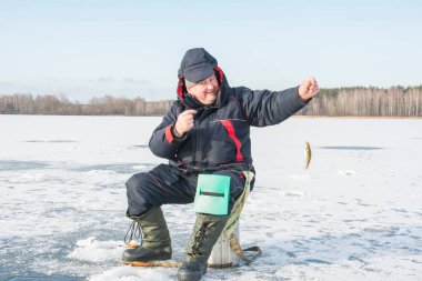 Bir kış öğleden sonra, bir adam donmuş bir nehirde balık tutar..