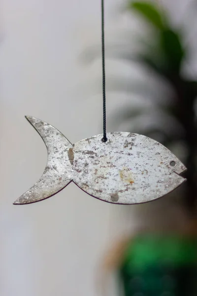 fish-shaped wind chime hanging by a thread