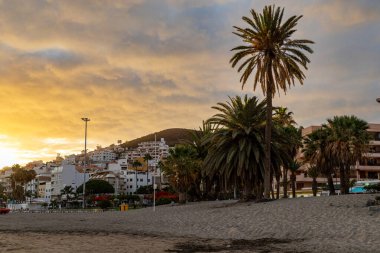playa blanca, spain - 24 Aralık, 2019: Sunset Playa Blanca plajı Palmiye ağaçları ile Playa del playa on