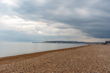 Bulutlu bir günde kumsal ve deniz manzarası.