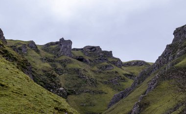 Yeşil ve mavi gökyüzü olan dağlık bir arazinin güzel manzarası.