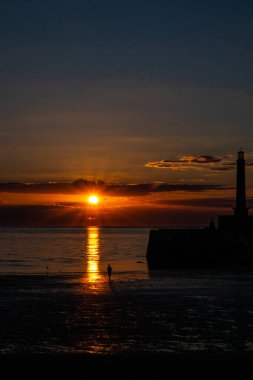 Sahildeki deniz feneri İsrail 'in kuzeyinde günbatımında