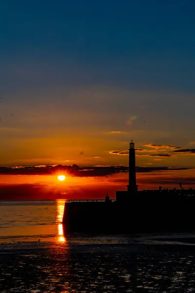 夕阳西下时海上灯塔的垂直拍 — 图库照片