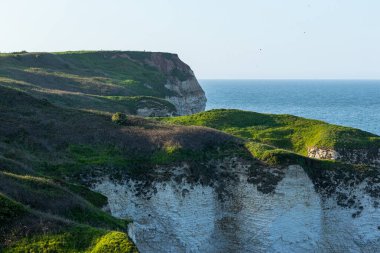 Uçurumu ve mavi gökyüzü olan güzel bir manzara.