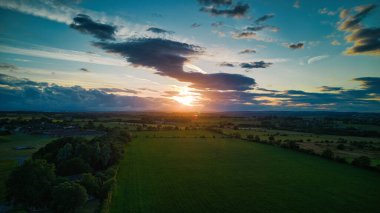 Bulutlu tarlada gün batımının havadan görüntüsü